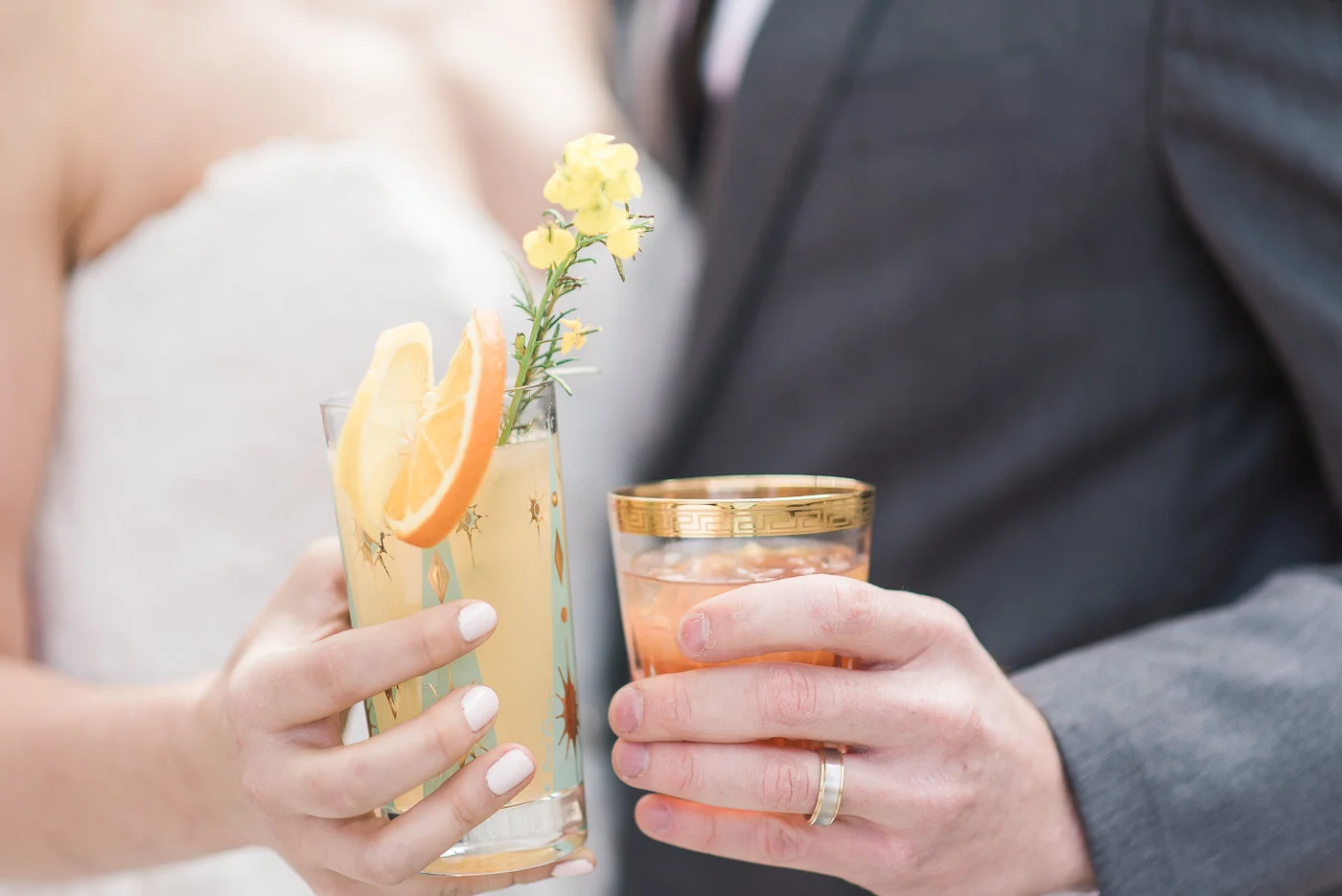Bride and groom holding elegant wedding cocktails.
