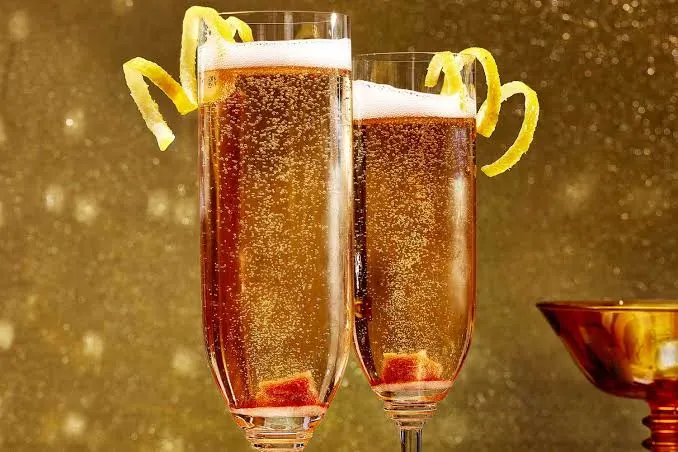 Champagne cocktails with lemon twists in elegant glasses.