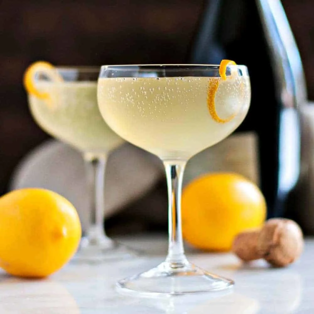 Elegant lemon french 75 champagne cocktails in coupe glasses.