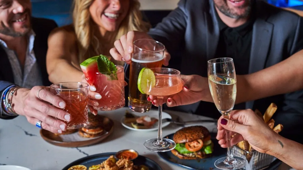 Guests toasting cocktails and champagne at a private event dinner