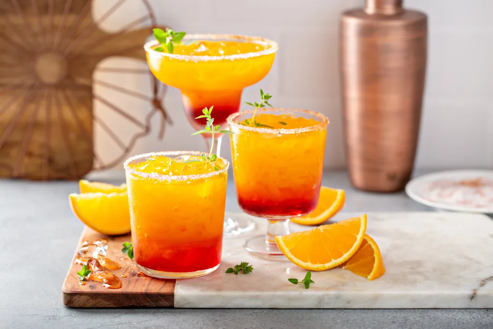 Orange tequila cocktails with citrus garnishes in elegant glasses.