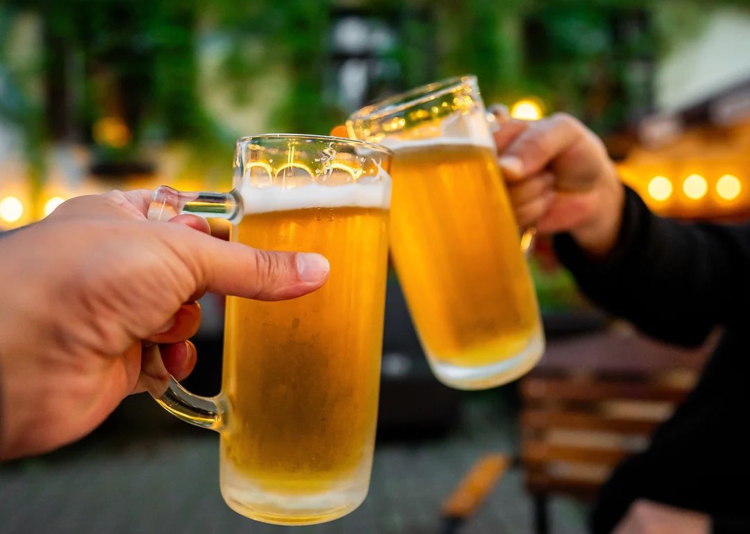 Two people clinking mugs of beer.