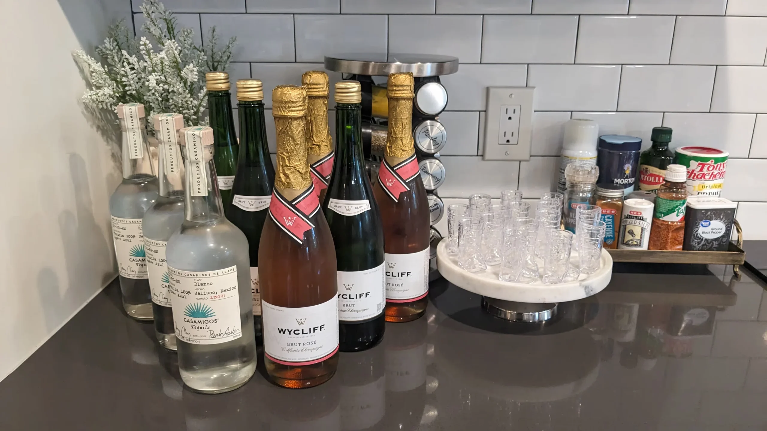 Alcohol bottles and glassware arranged on a kitchen counter.
