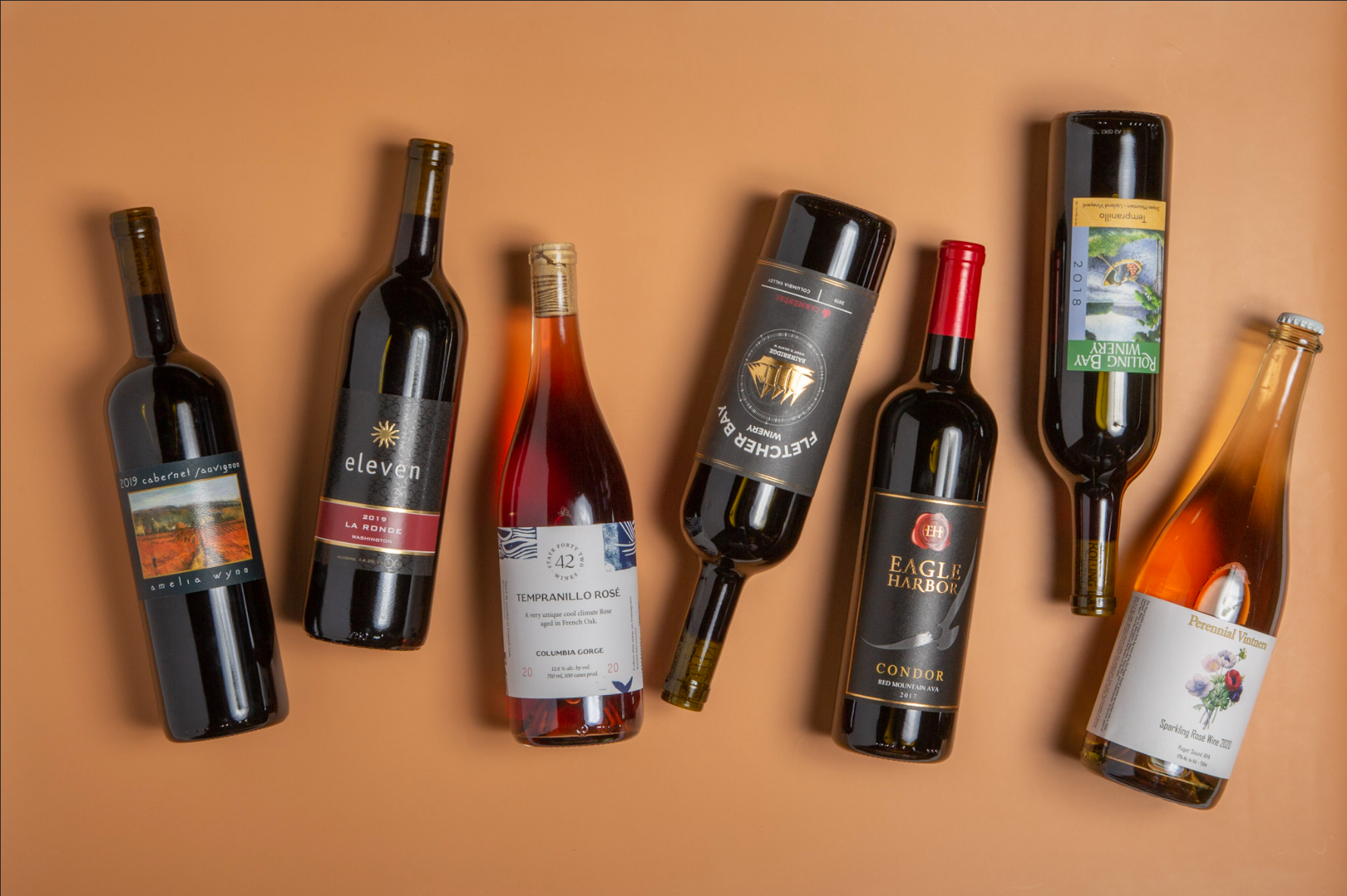 Assorted wine bottles arranged on a warm-toned background.