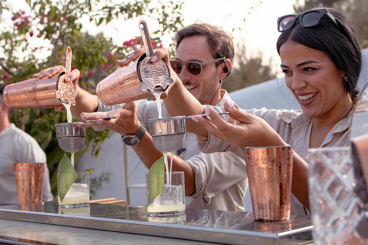 Bartenders pouring fresh cocktails at an outdoor Ibiza villa party.