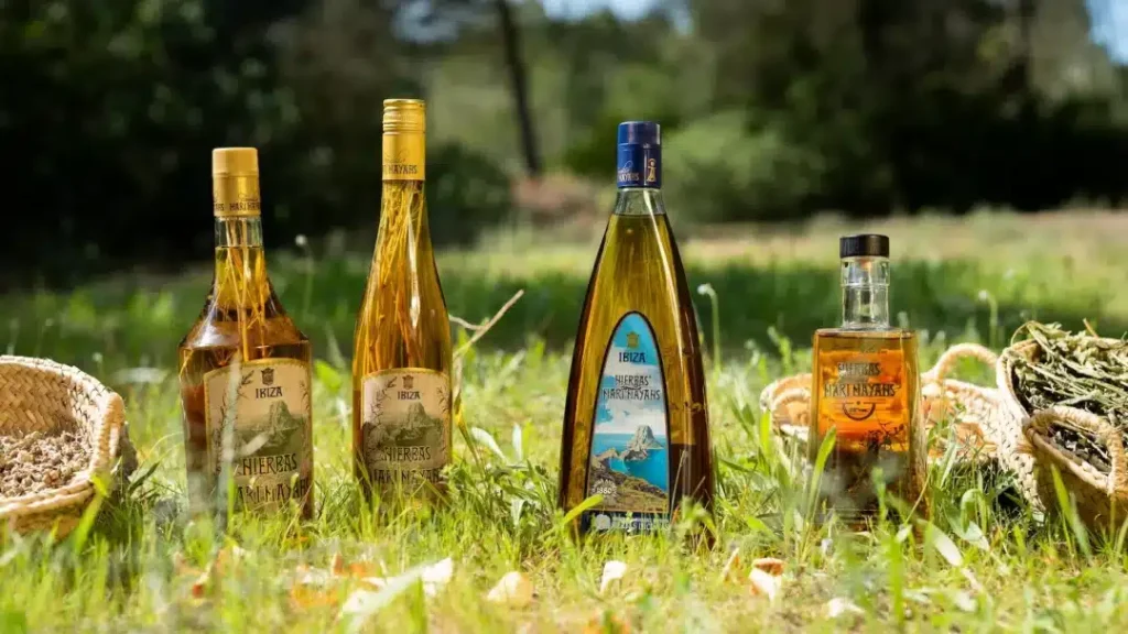 Bottles of traditional Ibiza herbal liqueur displayed outdoors.