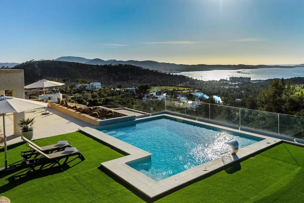 Crowded Ibiza pool party with live music, palm trees, and sunset views.