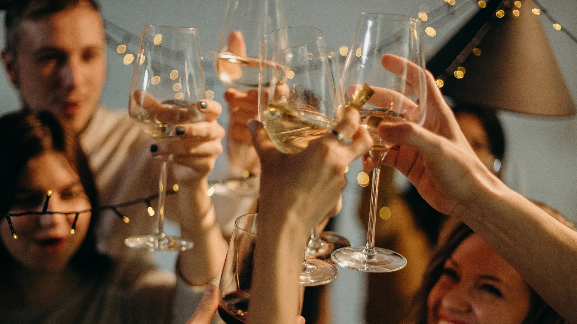 Friends toasting with wine glasses at a celebration.