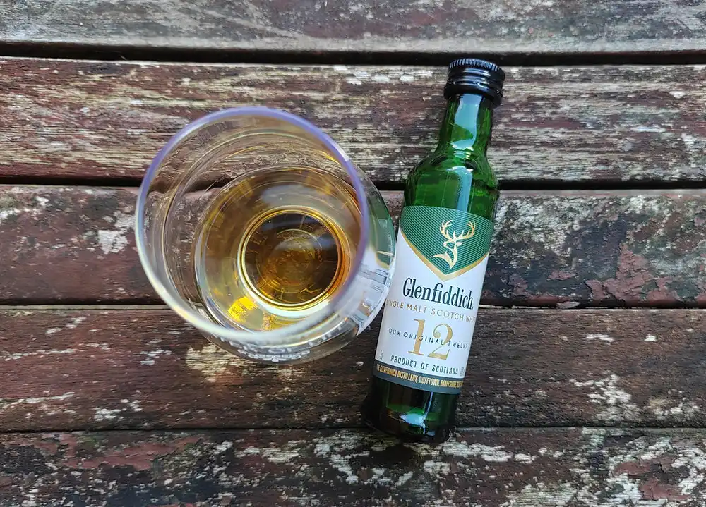 Glenfiddich 12 whisky bottle beside a glass of whisky.