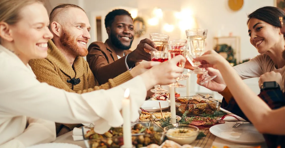 Guests raising wine glasses during a festive dinner celebration