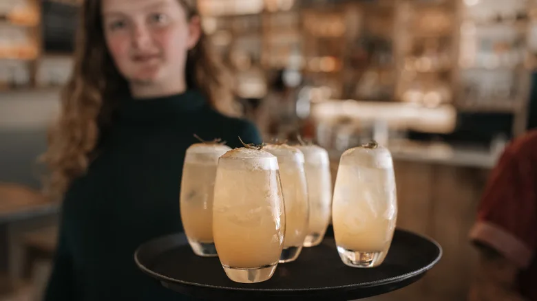Server carrying a tray of chilled cocktails.