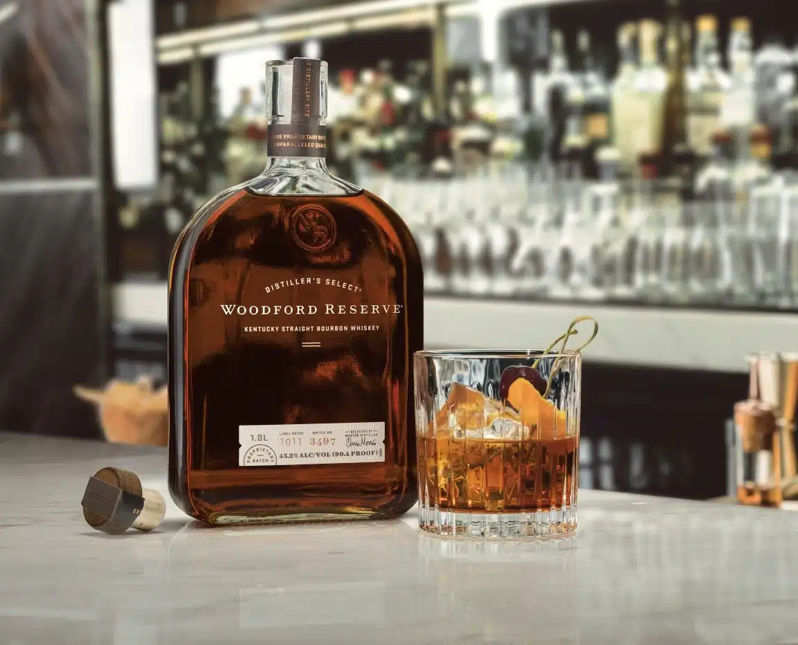 Woodford Reserve bourbon bottle beside a whisky cocktail.