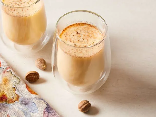 Creamy Christmas eggnog in glasses topped with nutmeg.