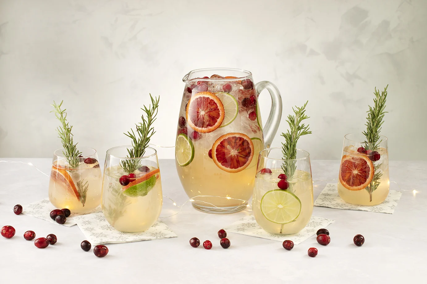Festive Christmas sangria with citrus slices, cranberries, and rosemary.