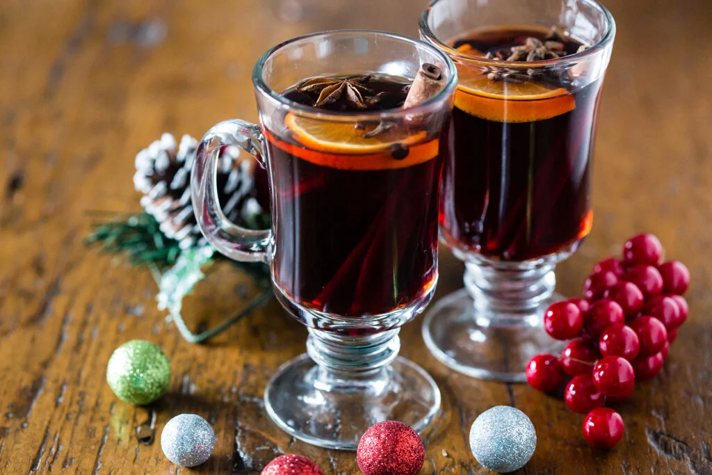 Two glasses of Christmas mulled wine with orange slices, cinnamon, and star anise.